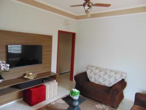 a living room with a chair and a flat screen tv at Casa Olímpia, piscina aquecida, ar condicionado, garagem 2 carros p in Olímpia