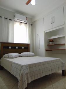 a bedroom with a bed and white cabinets at Casa Olímpia, piscina aquecida, ar condicionado, garagem 2 carros p in Olímpia +32 photos