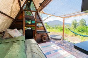 a tent with a couch and a hammock in it at Cloud Hills Glamping in Kintamani