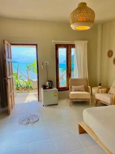 a bedroom with a bed and a view of the ocean at Indie Beach Bungalows in Ko Chang