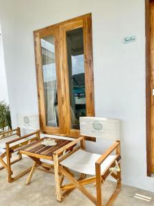 two chairs and a table in front of a window at Indie Beach Bungalows in Ko Chang