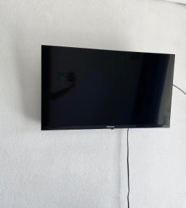 einen Flachbild-TV, der an einer Wand hängt in der Unterkunft Peyi Galante Évasion in Saint-Louis