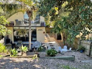 a house with a yard with chairs and trees at Between the Beach Flags, Luxury Family Hideaway - Recent Reno in The Entrance