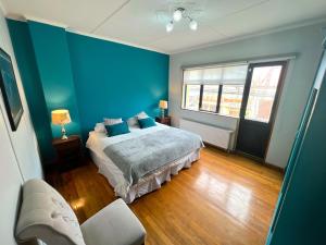a blue bedroom with a bed and a couch at Incredible Downtown Duplex with Interior Backyard in Punta Arenas
