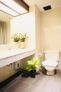 a bathroom with a toilet and a sink and a mirror at Thapaeplacehotel in Chiang Mai