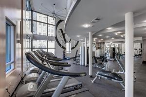 Luxury Residence Loft 3 Beds with Pool and Gym في لوس أنجلوس: صالة ألعاب رياضية مع صف من أجهزةالجري والأجهزة