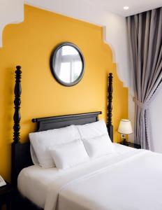 - une chambre avec un lit blanc et un miroir dans l'établissement The Fancy House, à Quy Nhơn