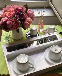 a table with a vase of flowers and a vase of pink flowers at Ambarabà B&B in Naples