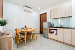 uma cozinha com mesa e cadeiras num quarto em AVIVA RESIDENCES em Thuan An