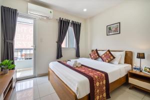 ein Schlafzimmer mit einem großen Bett und einem Fenster in der Unterkunft AVIVA RESIDENCES in Thuan An