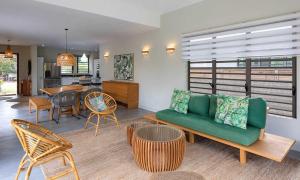 - un salon avec un canapé vert et des chaises dans l'établissement VILLA CHAMAREL, à Flic-en-Flac