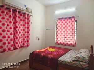 1 dormitorio con 1 cama y una ventana con cortinas rojas en HisGrace BEACH COTTAGES - Private Beach at MALPE, en Udupi