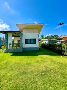 a small house with a lawn in front of it at KhaoLak Chill Out in Khao Lak