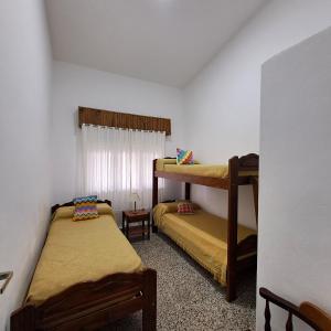 una habitación con dos literas y una ventana en Chalet La Mambu, en Mar de Ajó