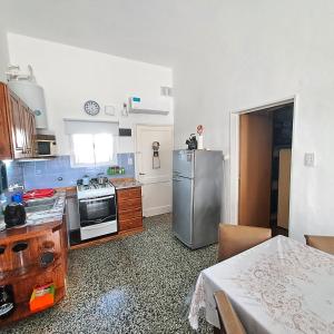 una cocina con estufa y refrigerador en Chalet La Mambu, en Mar de Ajó 16 fotos más