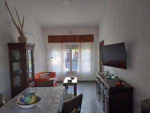 a living room with a flat screen tv and a table at Chalet La Mambu in Mar de Ajó +17 photos