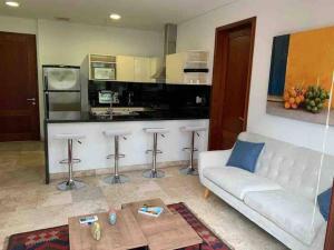 uma sala de estar com um sofá branco e uma cozinha em 212 Cartagena Walled City Magical Apt em Cartagena das Índias