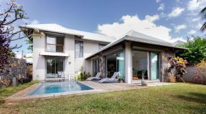a house with a swimming pool in the yard at VILLA CHAMAREL in Flic-en-Flac