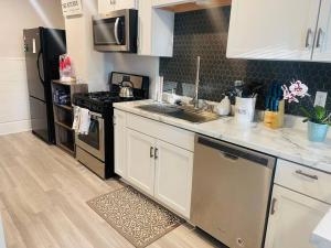 a kitchen with white cabinets and a sink and a stove at Modern Farmhouse on Kent Street in Saint Paul