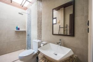 a bathroom with a sink and a toilet and a mirror at Yi's Garden Villa in Chiang Mai