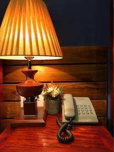 een lamp en een telefoon op een tafel naast een lamp gmaxwell gmaxwell gmaxwell bij Sunny A Hotel in Hue