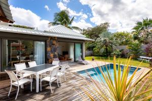 a patio with a table and chairs next to a pool at VILLA CHAMAREL in Flic-en-Flac