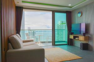 ein Wohnzimmer mit einem Sofa und einem großen Fenster in der Unterkunft Wongamat Tower Condominium in Pattaya North