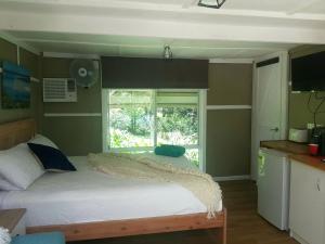 um quarto com uma cama grande e uma janela em Forest view bungalow em Nambucca Heads