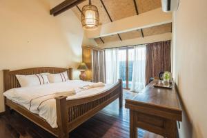a bedroom with a large bed and a table at Yi's Garden Villa in Chiang Mai