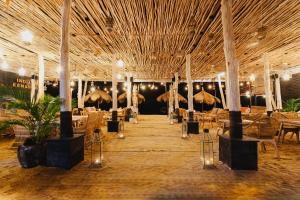 een restaurant met tafels, stoelen en parasols bij Indiana Kenanga Boutique Hotel & Spa in Nusa Lembongan