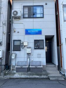 un edificio con una señal azul en el costado. en 民宿　setouchi, en Takamatsu