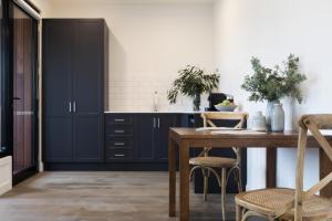 a kitchen with a table, chairs and a table cloth at Brooklands Apartments in Healesville