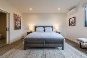 a bedroom with a bed and two lamps on two tables at Brooklands Apartments in Healesville
