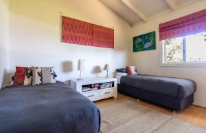 1 dormitorio con 2 camas y sofá en Earl's Place Gracetown Beach Shack, en Gracetown