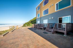 ein Gebäude mit Bänken am Strand in der Unterkunft Sailor Jack Oceanfront Motel in Lincoln City