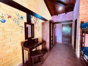um corredor com uma mesa e uma parede com um mural em Hostería EL Trapiche Lodge & Spa em Baños