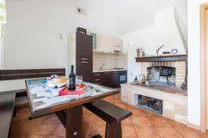a kitchen with a table and a fireplace at Holiday home Branko - large terrace in Postira