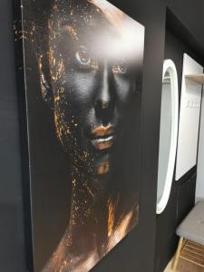 Un ritratto di una donna con brillantini d'oro su un muro di Apartament incantator Iasi Copou a Iaşi