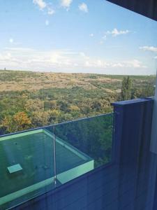 uma varanda de vidro com vista para um campo em Apartament incantator Iasi Copou em Iaşi