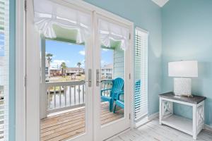 a door leading to a balcony with a blue chair at Coastal Bliss in Rockport