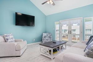 a living room with two couches and a tv at Coastal Bliss in Rockport