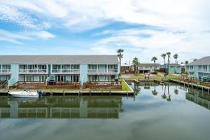 a building with a dock and a boat in the water at Coastal Bliss in Rockport