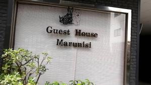 una porta bianca del garage con le parole della guest house marmutilus di Marunishi ad Osaka