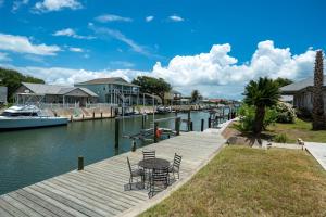 un muelle con mesa y sillas junto al agua en Gone Coastal, en Rockport