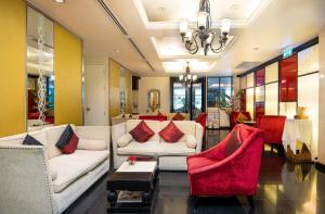 a living room with white couches and red chairs at Admiral Premier Bangkok in Bangkok