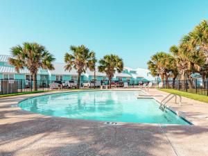 a swimming pool with palm trees in a resort at Kontiki Bayfront Condo 405 in Rockport