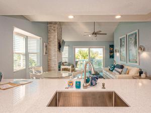 a kitchen with a sink and a living room at Kontiki Bayfront Condo 405 in Rockport