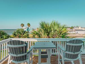 two chairs and a table on a balcony with the ocean at Kontiki Bayfront Condo 405 in Rockport