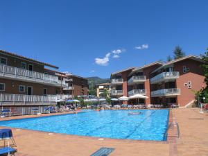 a swimming pool at a hotel with people sitting around it at Residence Villa Rosa in Garda