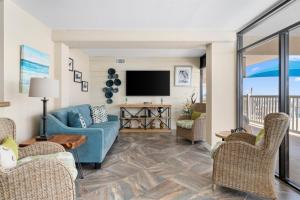 a living room with a blue couch and a tv at LR 117 - Gone Fishing in Rockport